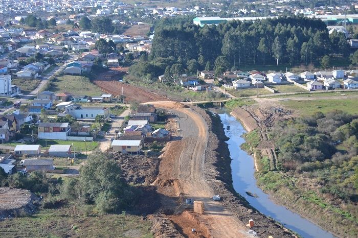 Vista aérea de obra viária ao lado de canal